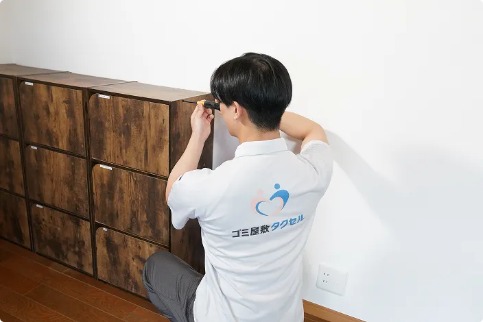 ゴミ屋敷タクセル東京の男性スタッフが家具を確認している様子