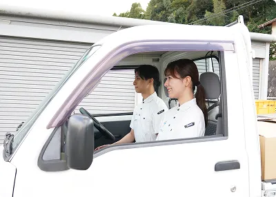 ゴミ屋敷タクセル東京の女性スタッフと男性スタッフが軽トラに乗っている様子